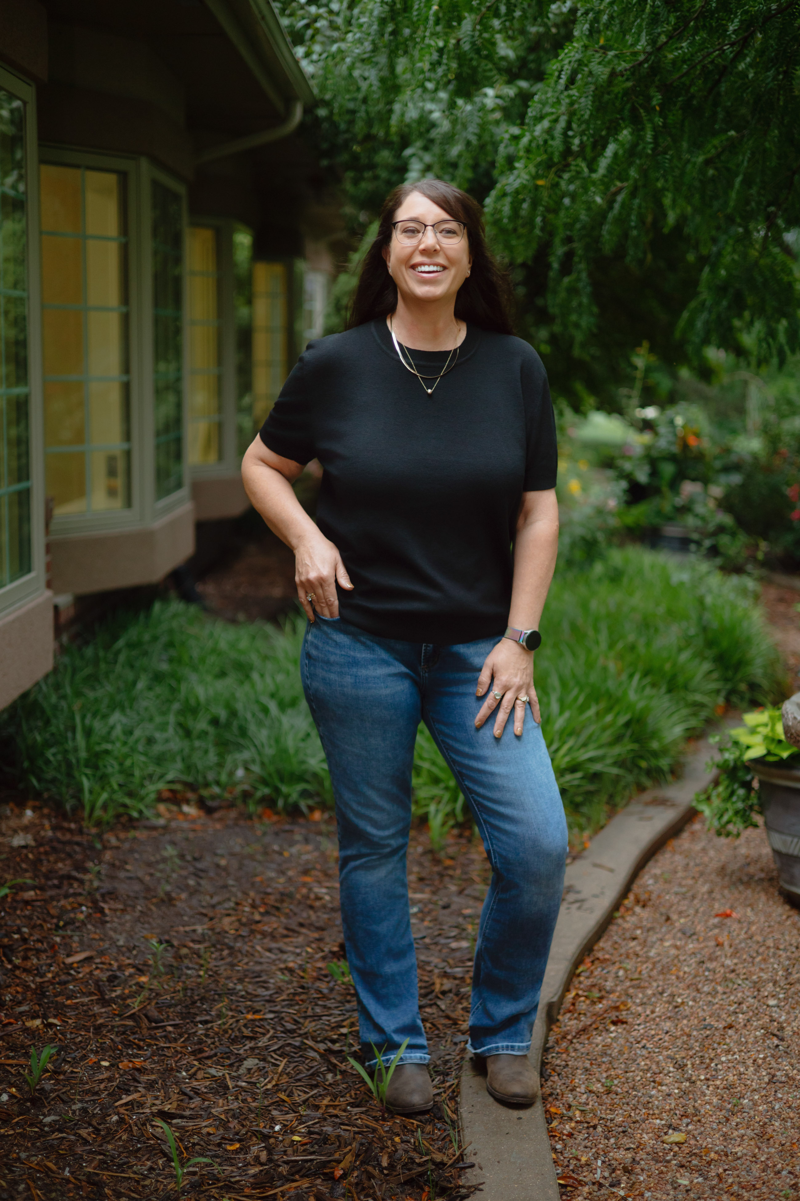 A relaxed three-quarter length staff portrait on a garden path