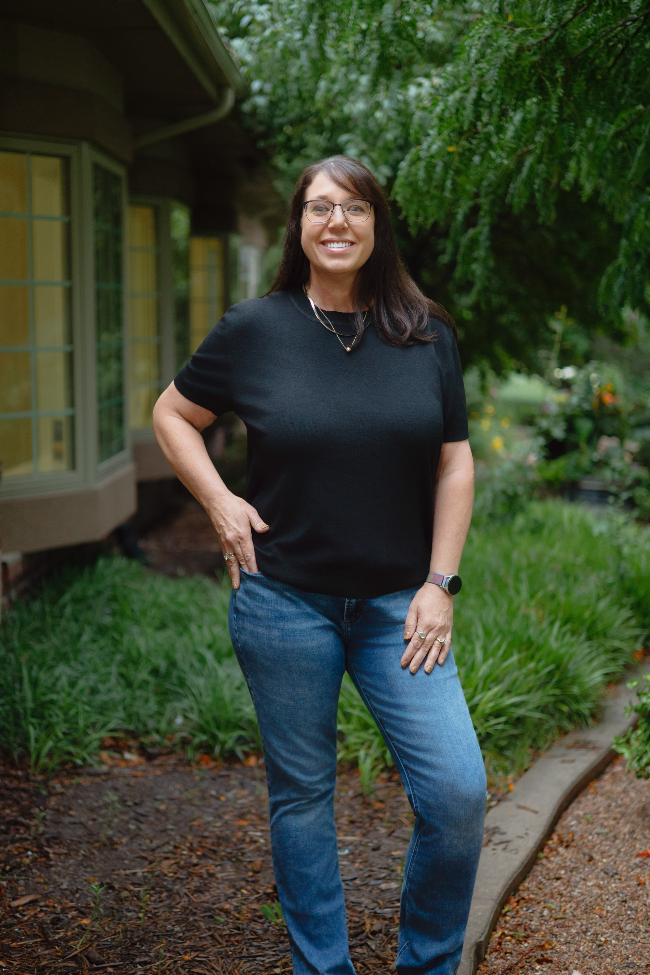 Staff headshot of a woman with glasses, photographed outdoors