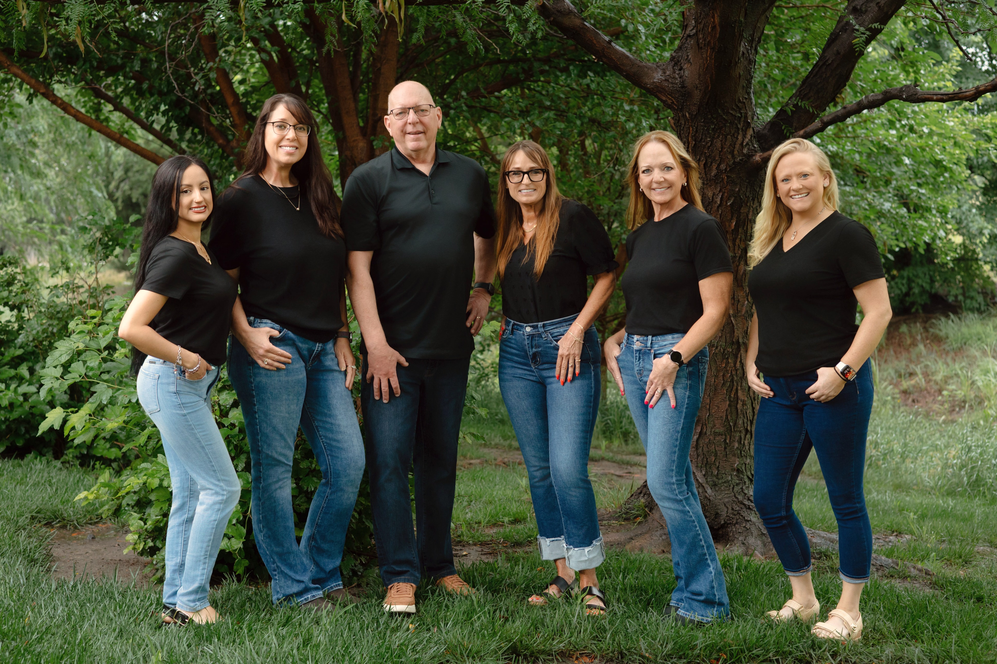 A team of six photographed together outdoors for their business portraits